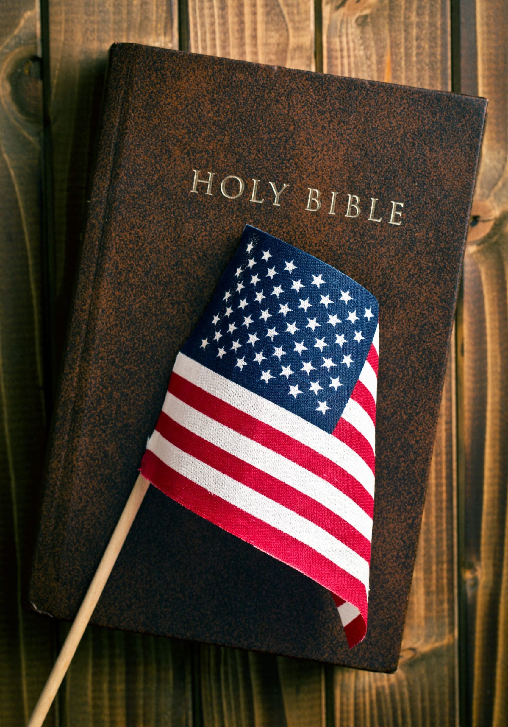 holy bible with american flag on wooden background